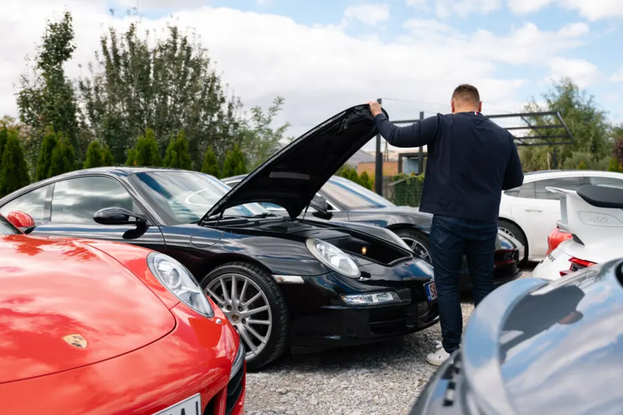 Buyer inspecting a used car on a dealer lot