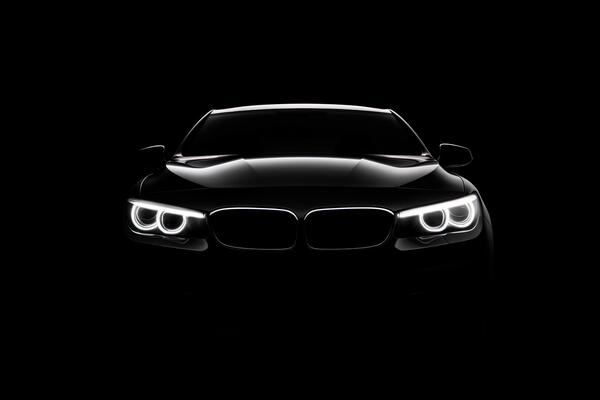 front view dark silhouette of a modern luxury black car isolated on black background ai generated free photo